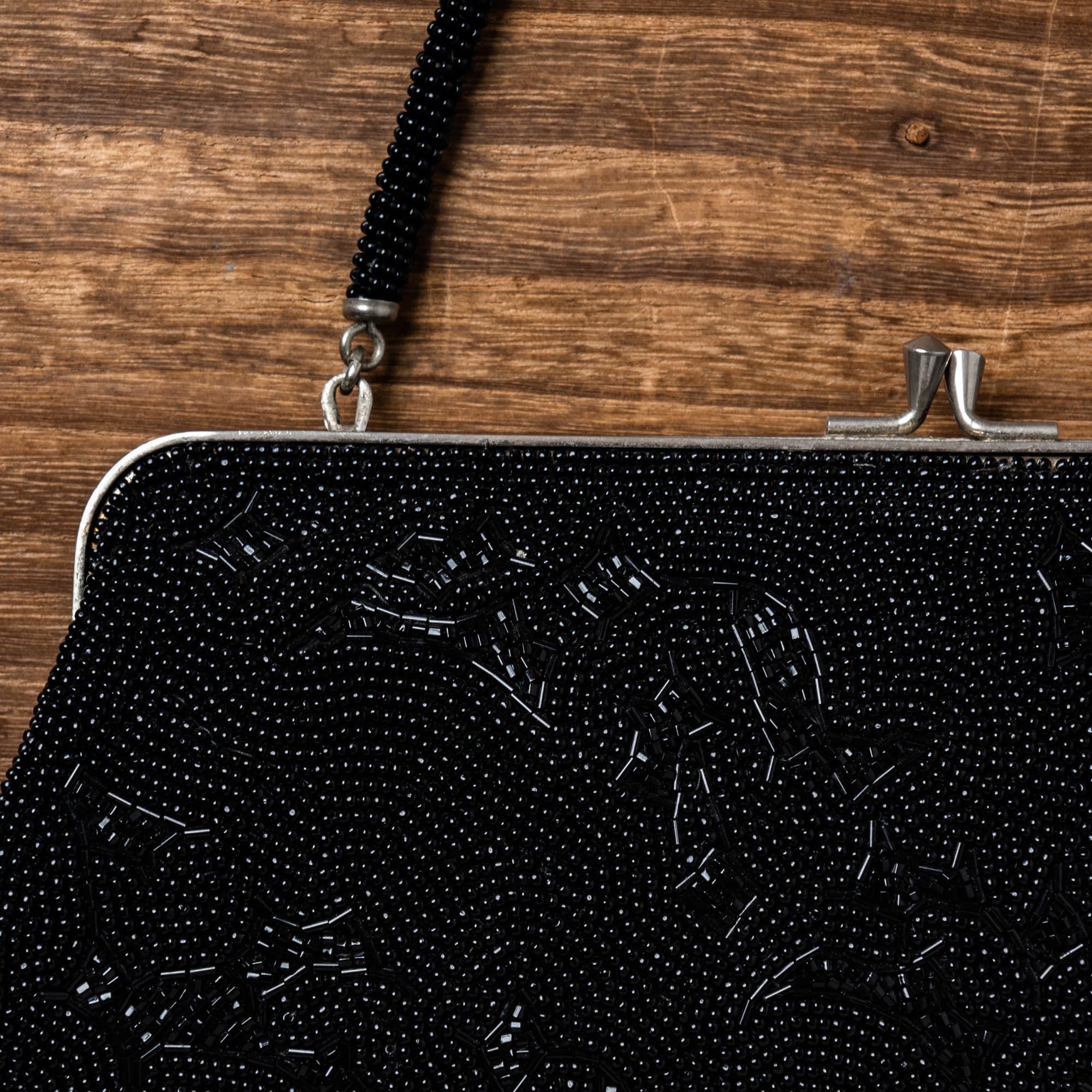 絵柄も留め具もとがったデザインの黒い総ビーズバッグ