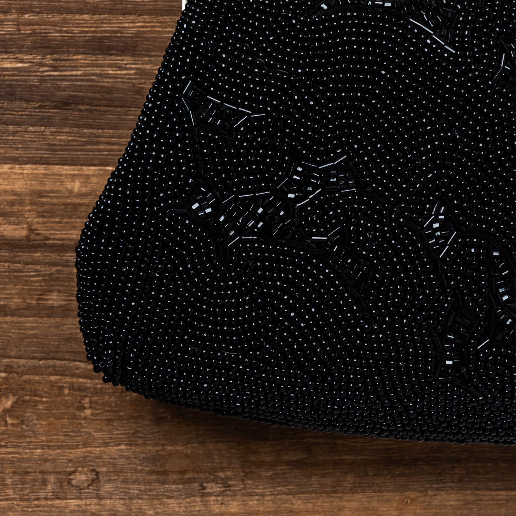 絵柄も留め具もとがったデザインの黒い総ビーズバッグ