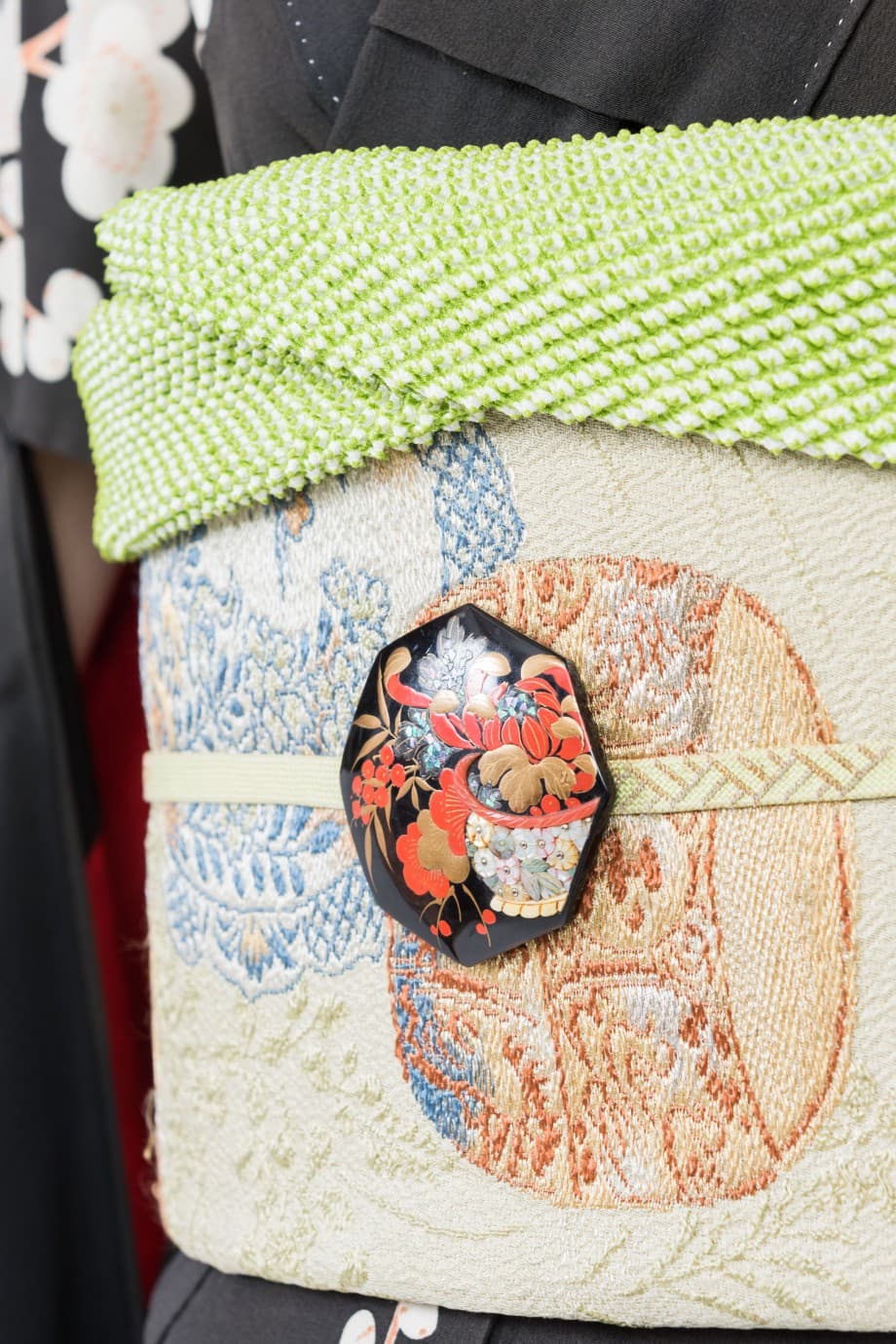 【和装の結婚式】渋めの色合いで花薬玉が描かれた黒振袖