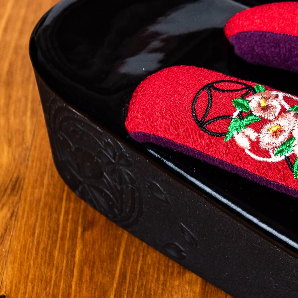 黒い土台に赤と紫の鼻緒、七宝と小花の手刺繍の草履