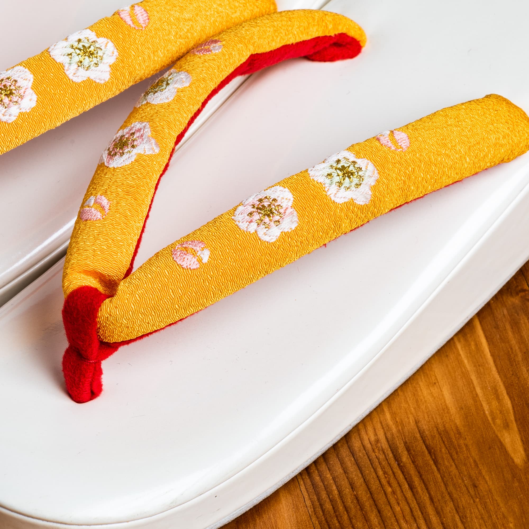 白い土台に赤と黄色の鼻緒、桜の手刺繍の７才用草履